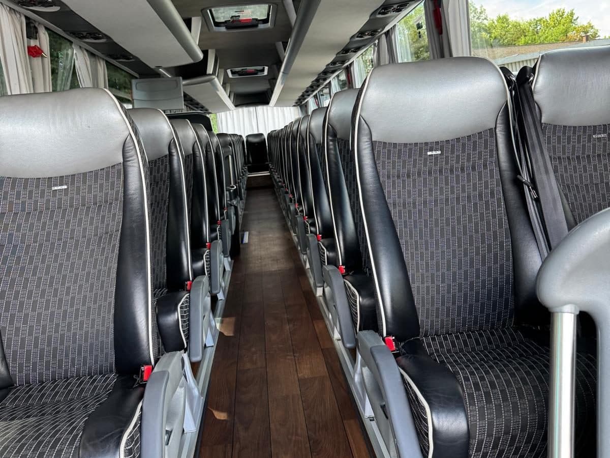 Innenraum des MAN Fernreisebusses mit Sitzreihen und Gepäckablagen